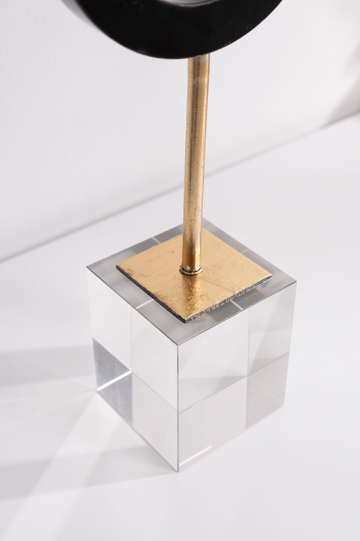 GDECO - Escultura circulo mármol negro, pie dorado con base metraquilato transparente. 12x31x7 cm